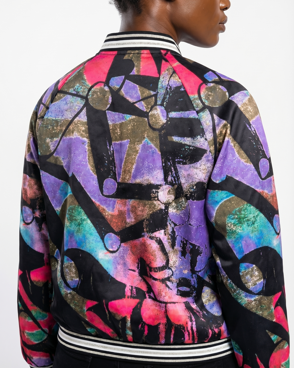 Multicolored patterned jacket worn by a person on a white background