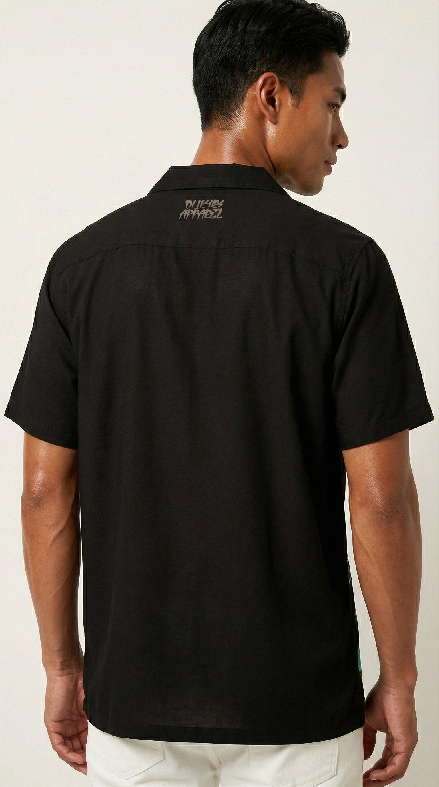 Man wearing a black shirt with text on the back against a white background