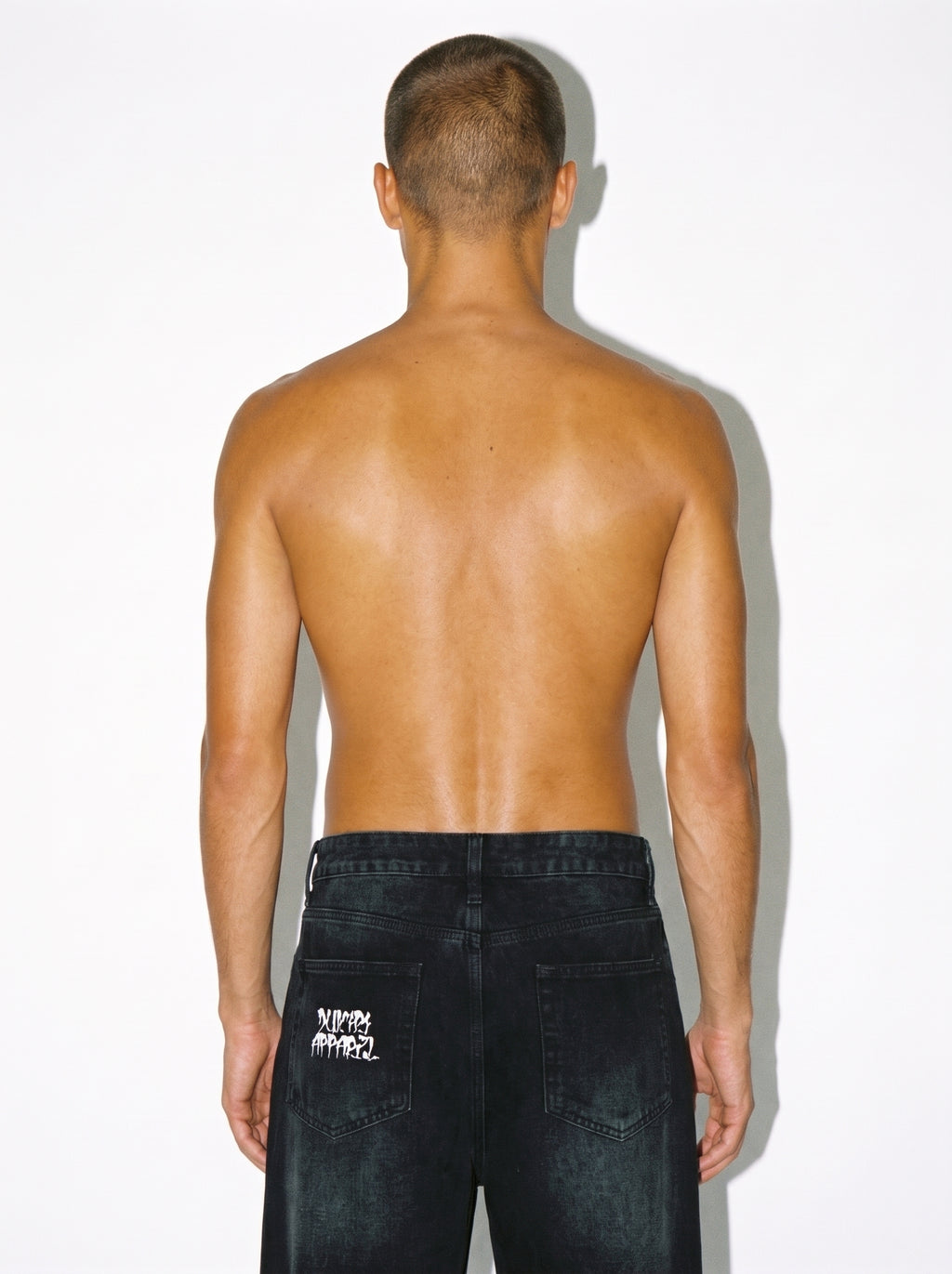 Man wearing White Lotus vintage washed wide leg denim jeans with sunfade graphic