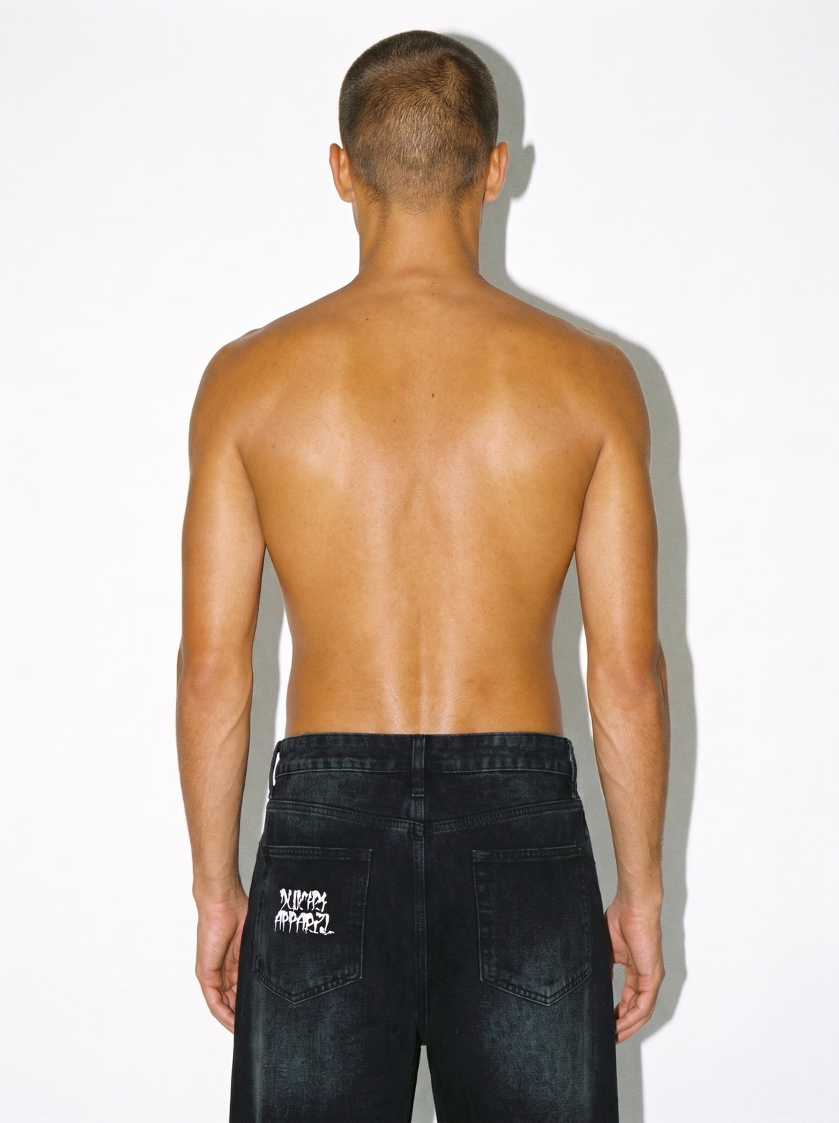 Man wearing White Lotus vintage washed wide leg denim jeans with sunfade graphic