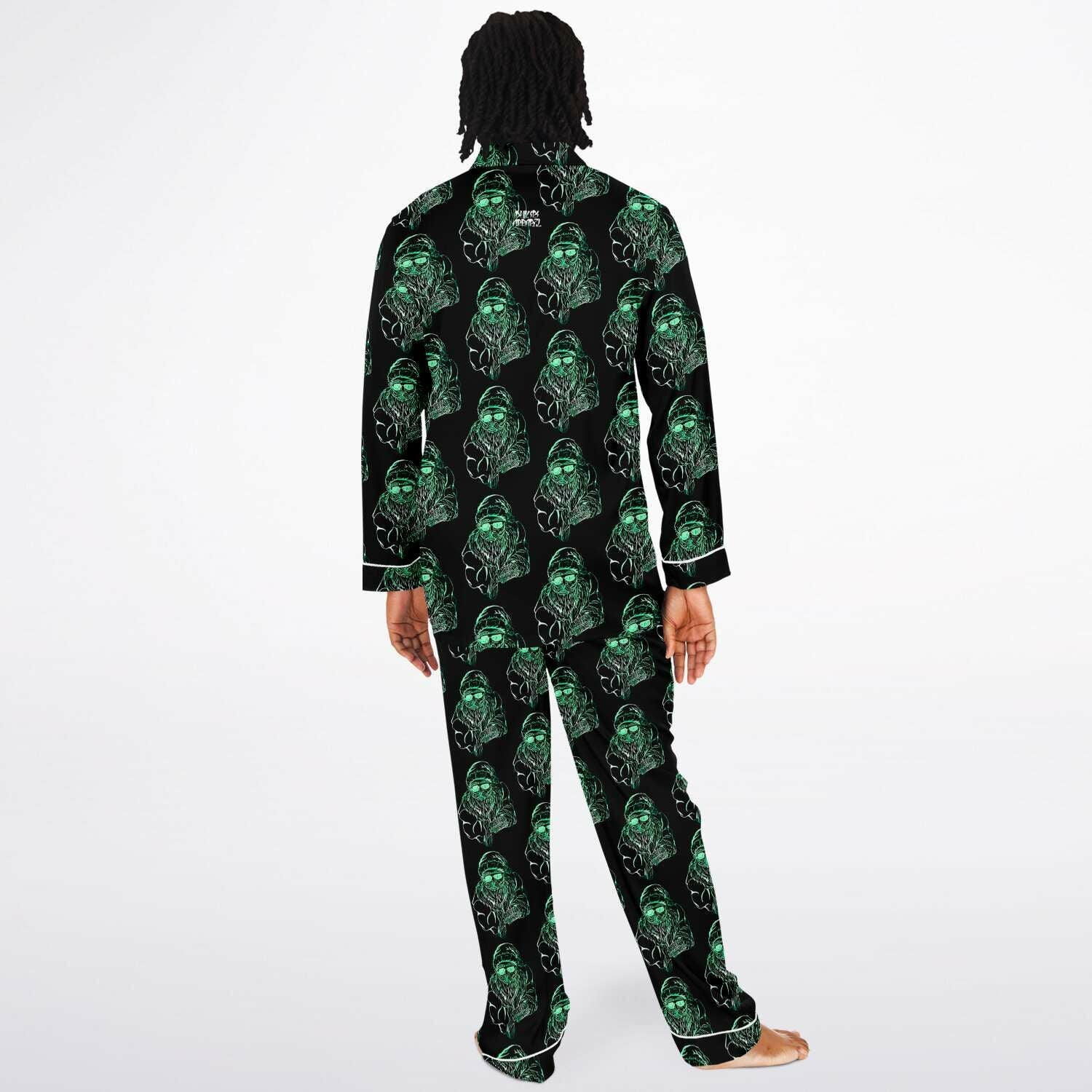 Person wearing a black pajama set with green alien pattern on a white background