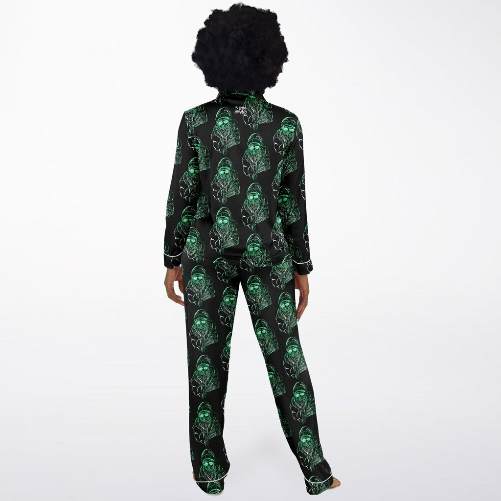 Person wearing a black pajama set with green skull patterns on a white background