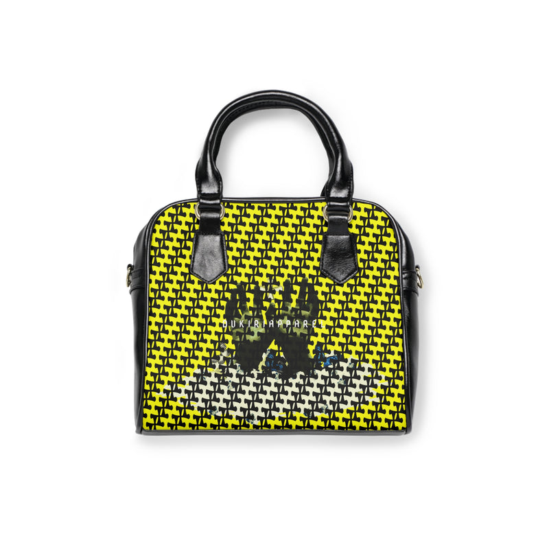 A shoulder handbag with a black and yellow checkered pattern, featuring a graphic of three figures on the front.