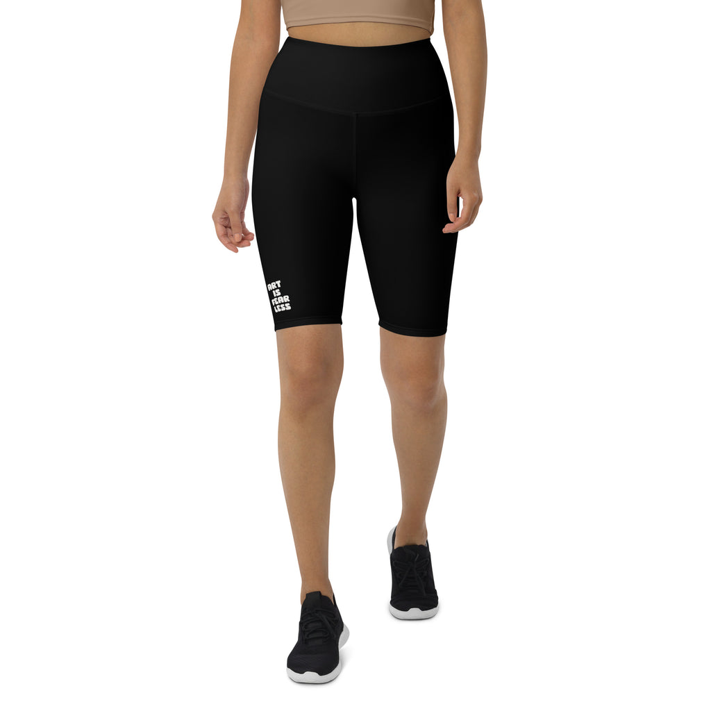 Person wearing black athletic shorts with a logo on a white background