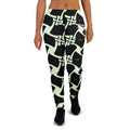 Person wearing black leggings with a light green abstract pattern on a white background