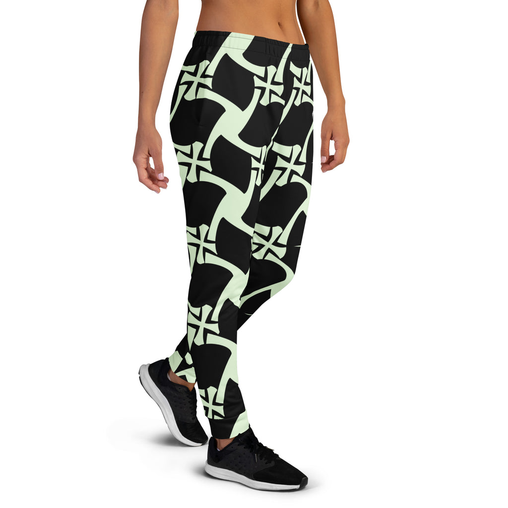 Person wearing black and green patterned leggings on a white background