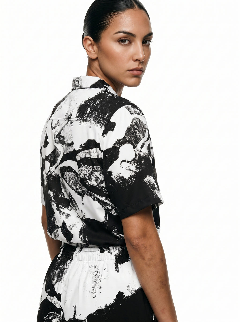 Woman wearing a black and white patterned shirt on a white background