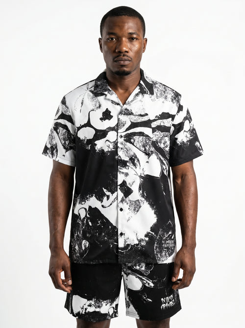 Man wearing a black and white patterned shirt on a white background